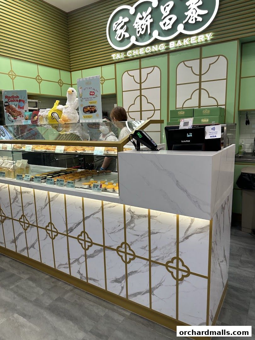 The interior of Tai Cheong Bakery with a display of pastries and a cashier counter.