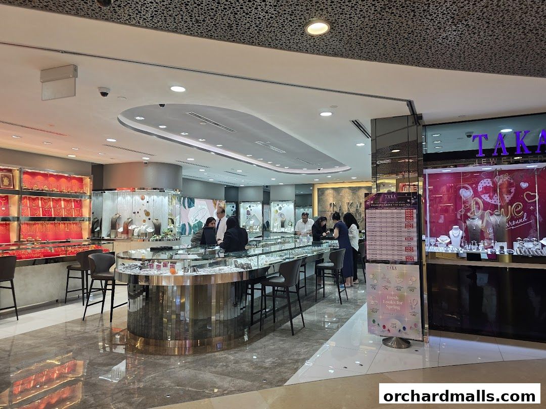 Interior view of a well-lit jewelry store with displays of necklaces, rings, and customers browsing.