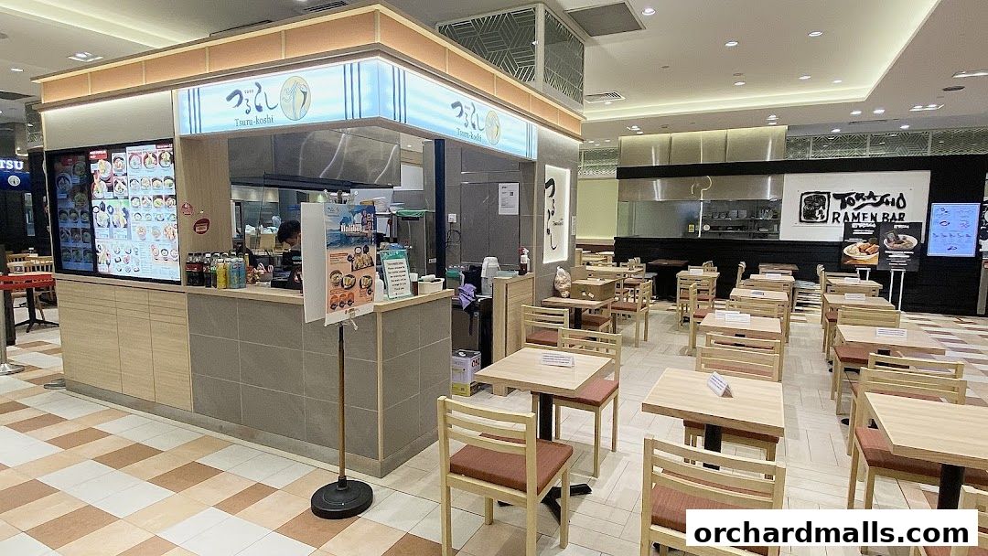 Interior view of a food court with ramen shops and seating areas.