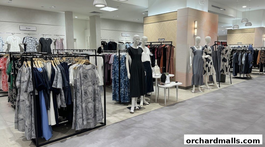 Interior view of a clothing store with mannequins and racks of dresses.
