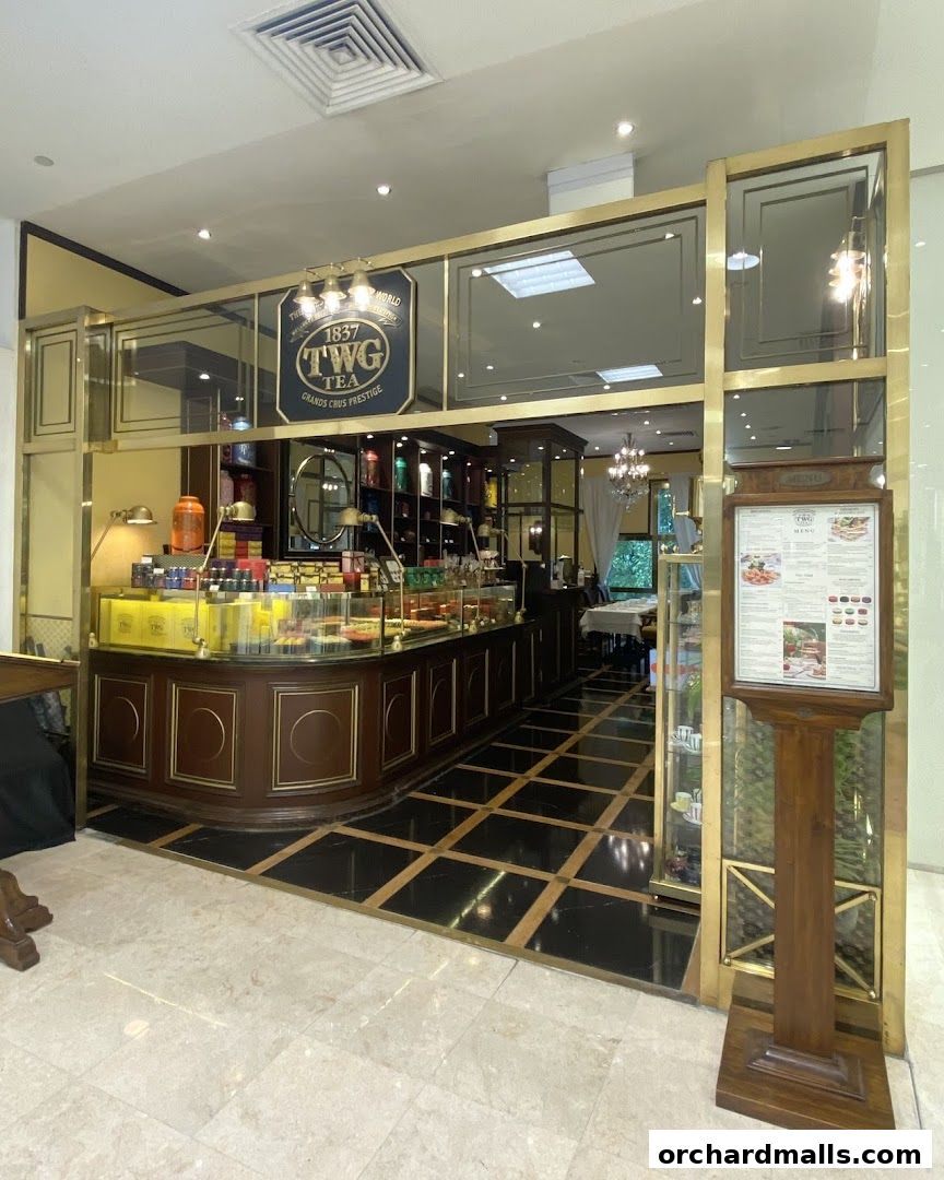 Elegant TWG Tea shop interior with display cases filled with teas and pastries.