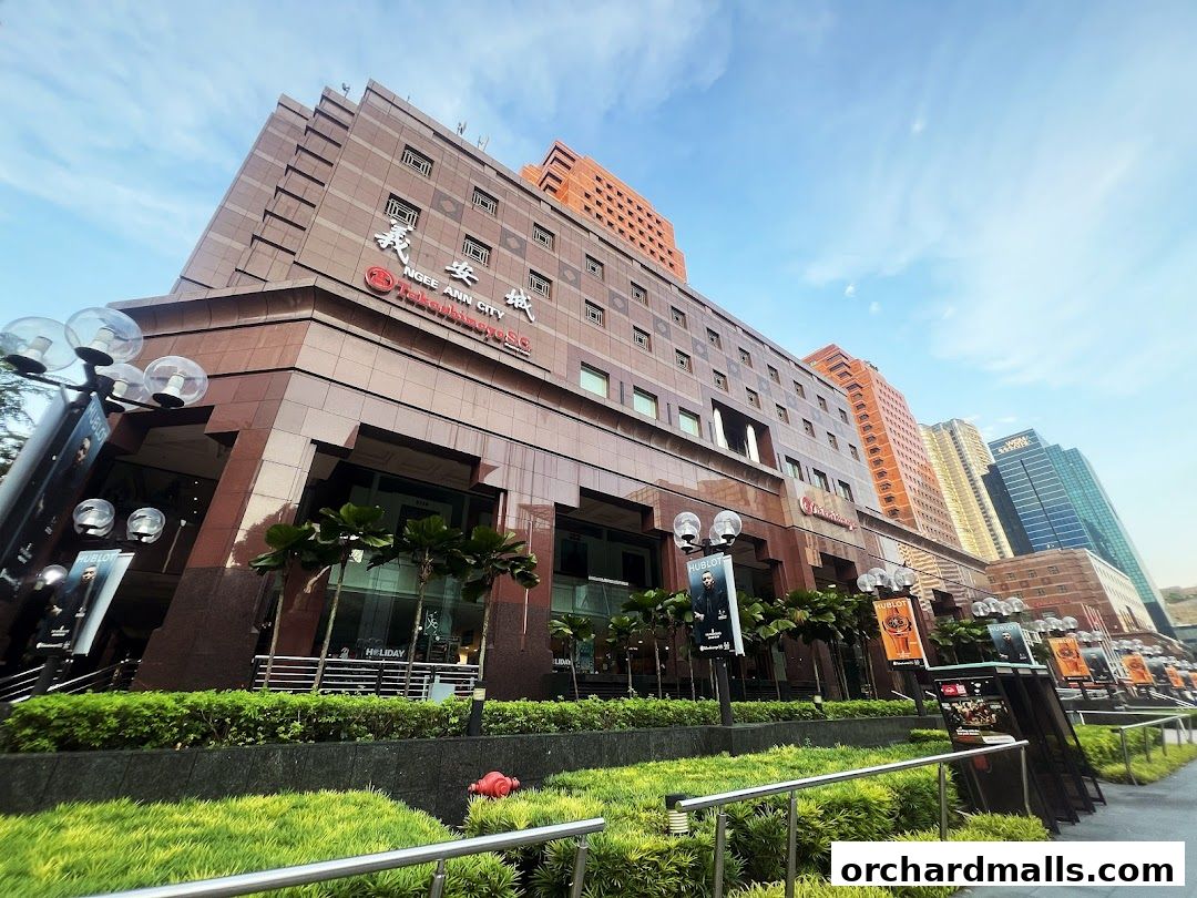 Exterior view of Takashimaya Department Store building with signage and surrounding greenery.