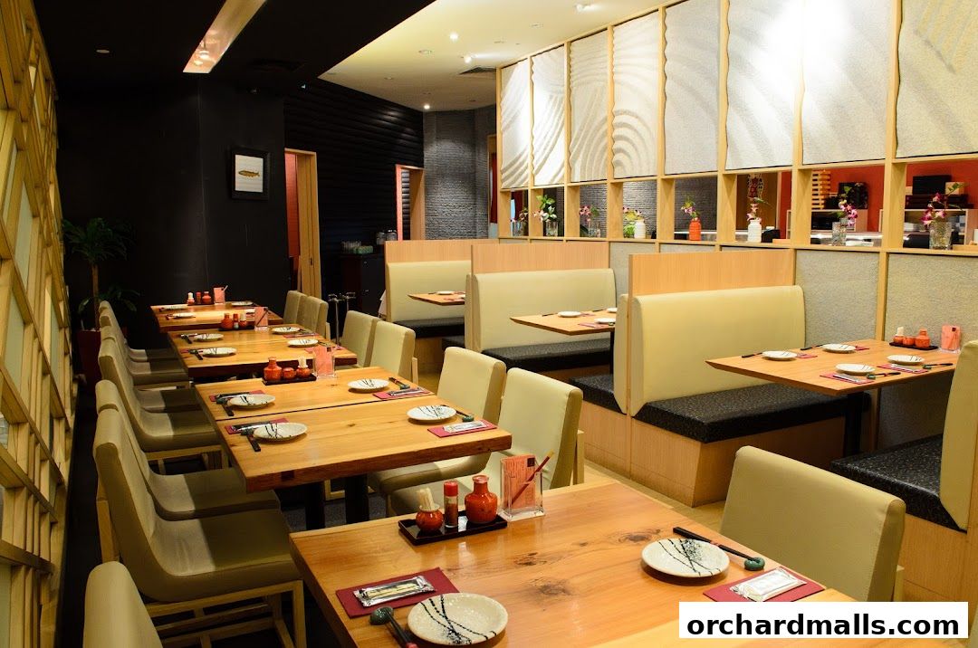 Interior of a Japanese restaurant with wooden tables, booths, and decorative shelving.