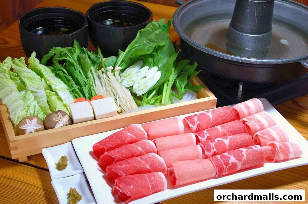 A hot pot meal with fresh vegetables, tofu, mushrooms, and thinly sliced meats.