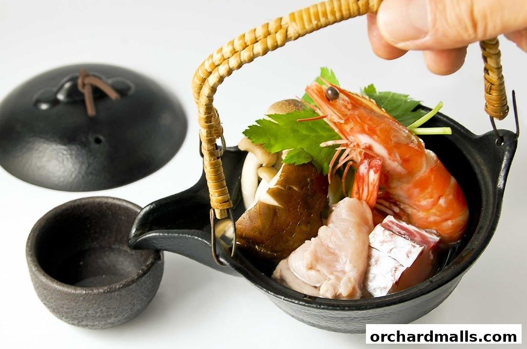 A hand holds a traditional Japanese pot filled with seafood and mushrooms.