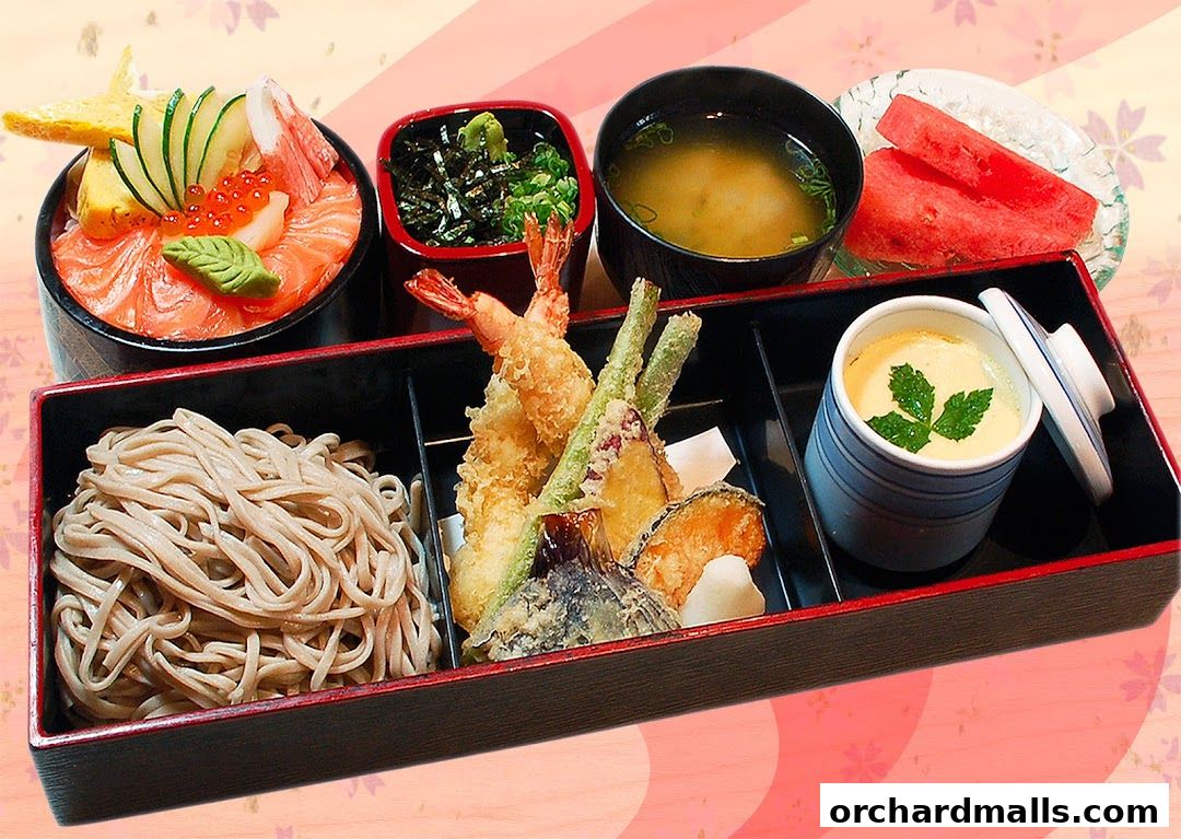 A bento box featuring salmon sashimi, tempura, soba noodles, soup, and chawanmushi.
