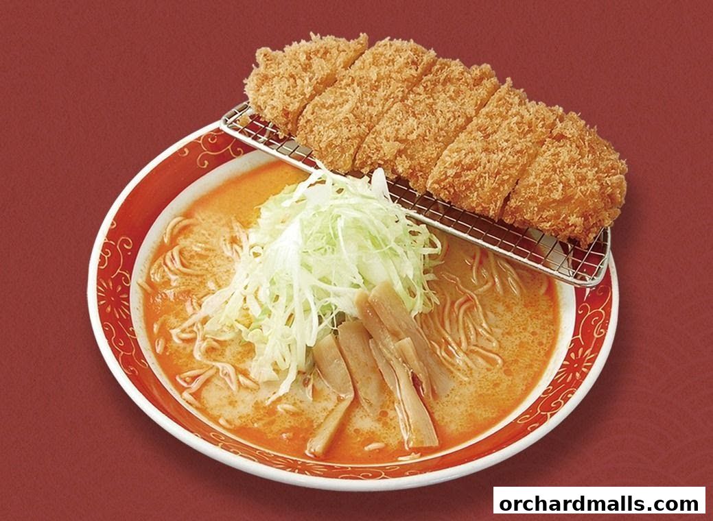 A bowl of ramen topped with crispy fried pork cutlet and shredded cabbage.