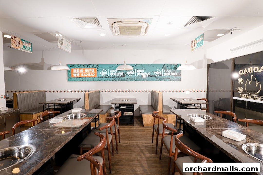 Interior view of TangBaoBao restaurant with tables, booths, and decorative wall banner.