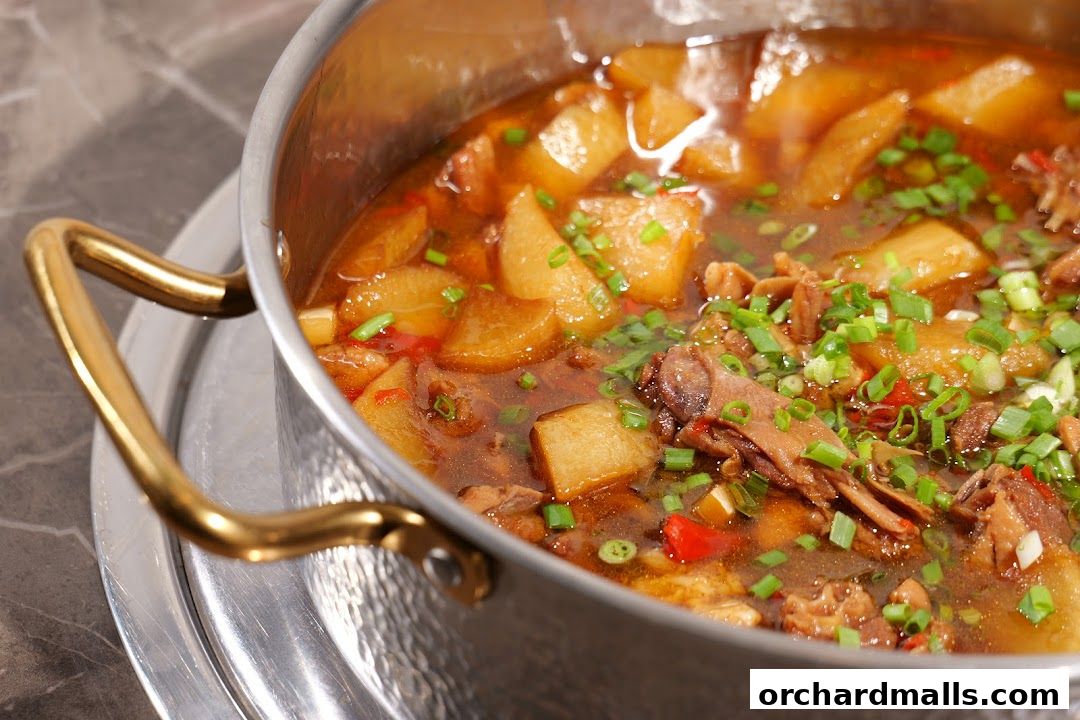 A close-up of a pot of stewed pork belly with radish and scallions.