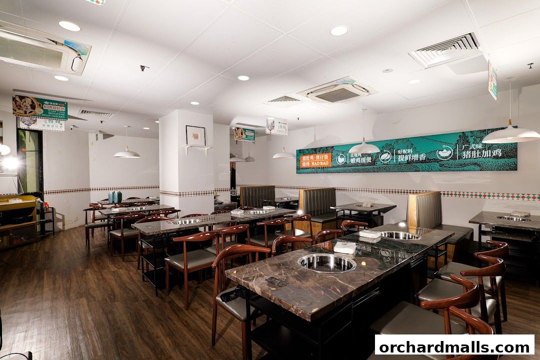 Interior view of a restaurant with tables set for dining, featuring a prominent banner.