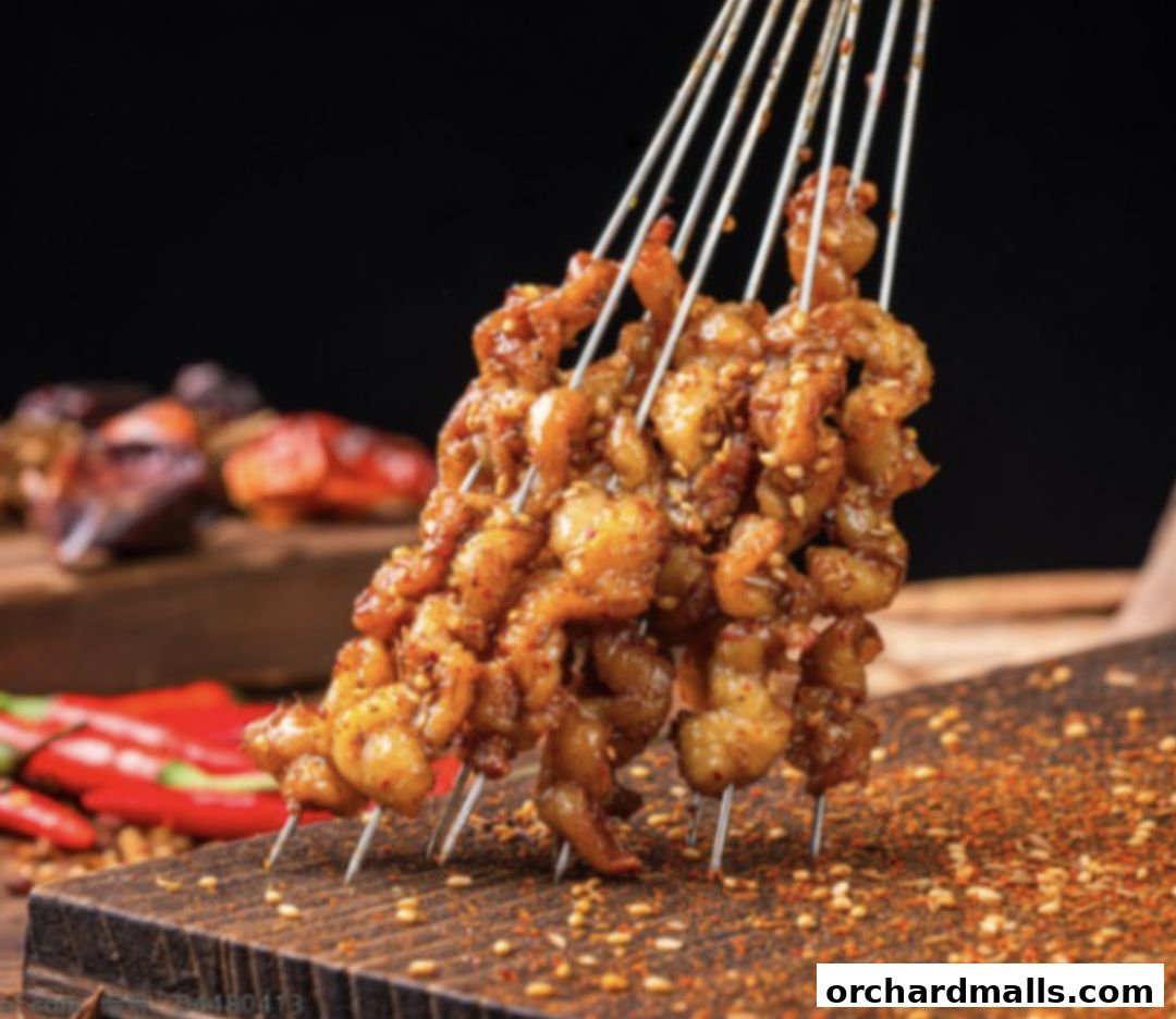 Skewers of seasoned meat with chili peppers and spices on a wooden board.