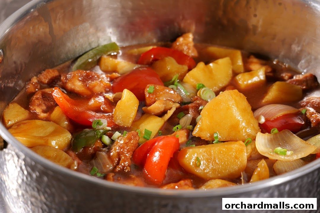 A close-up shot of a hearty stew with potatoes, bell peppers, and meat in a rich sauce.