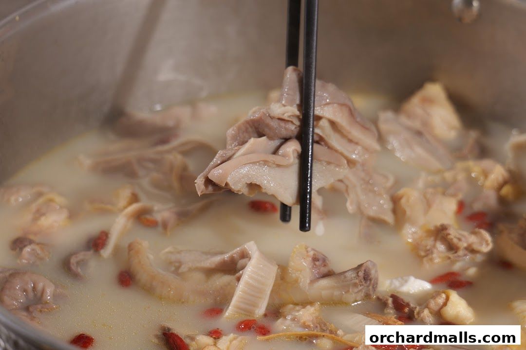 Close-up of a steaming pot of pork stomach and chicken soup with goji berries.