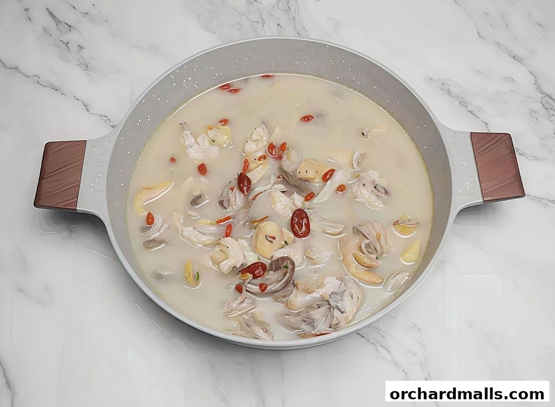 A pot of creamy soup with chicken, goji berries, and other ingredients.