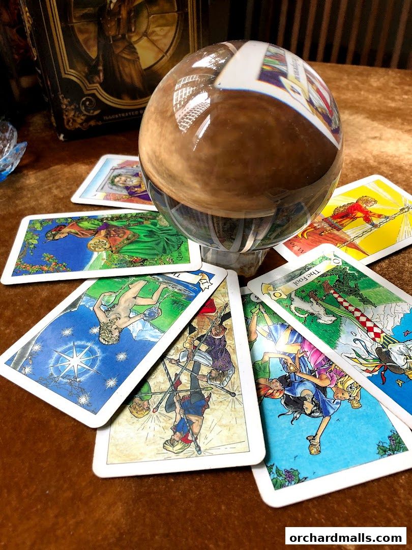 Tarot cards and a crystal ball are arranged on a velvet surface.