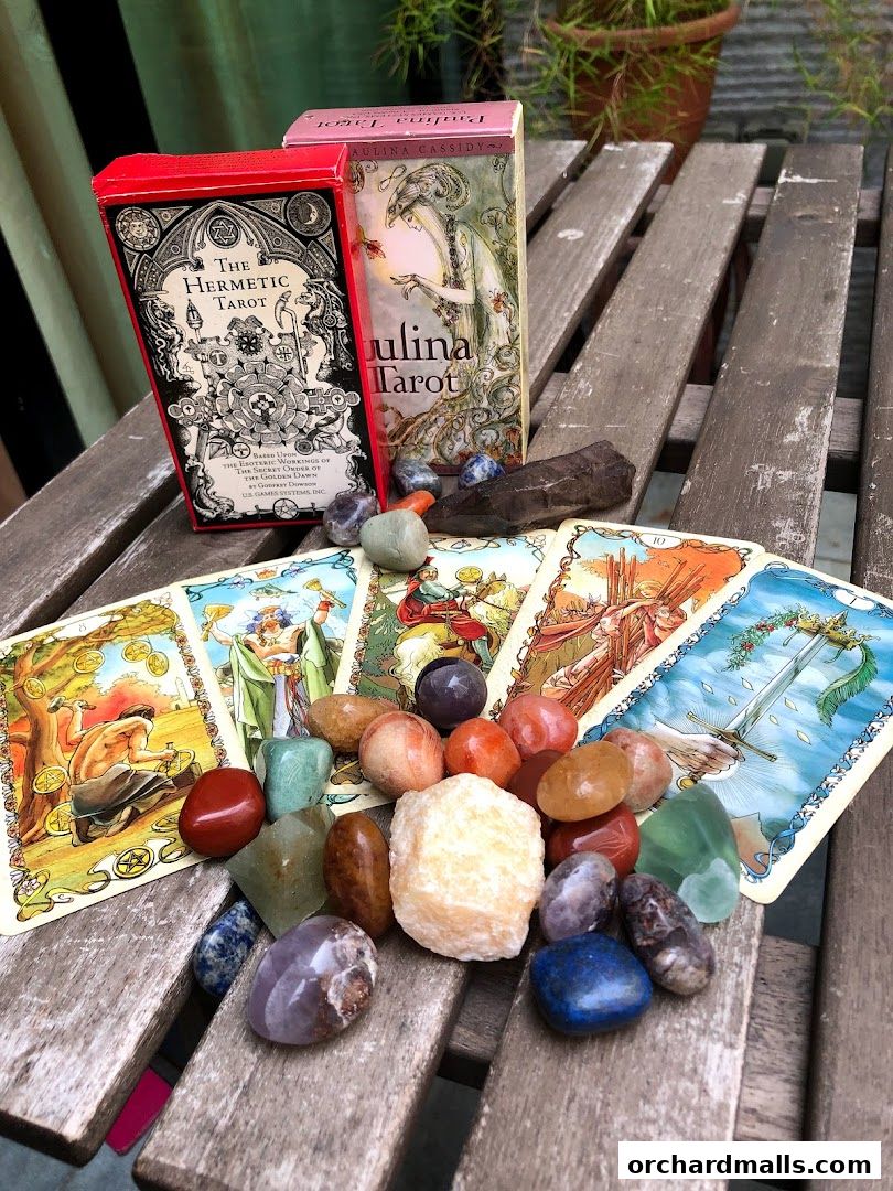 Tarot cards and crystals are displayed on a wooden surface, suggesting a mystical or spiritual theme.