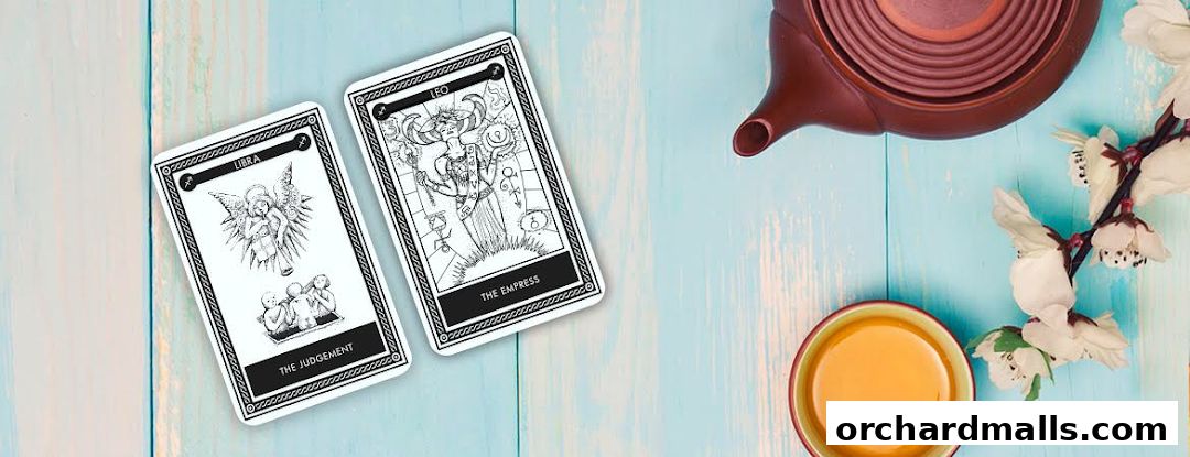 Tarot cards, a teapot, and a cup of tea on a light blue wooden surface.