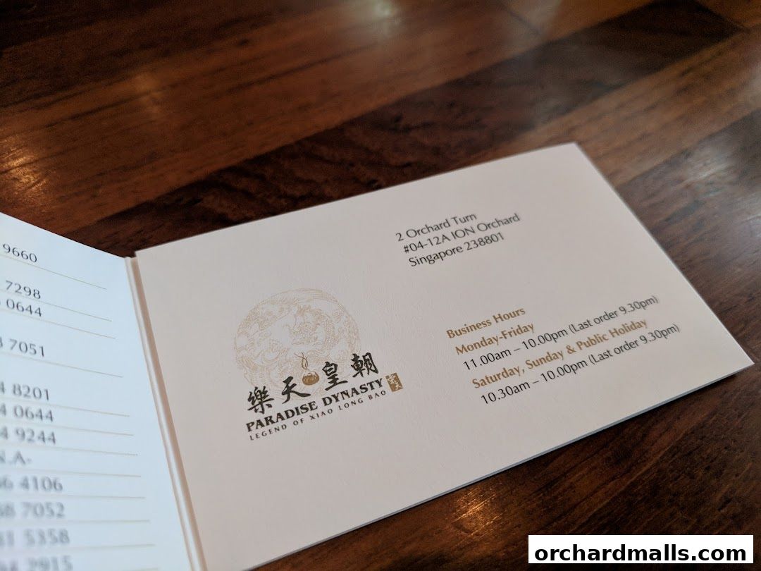 A brochure for Paradise Dynasty restaurant at ION Orchard, featuring business hours and contact information.