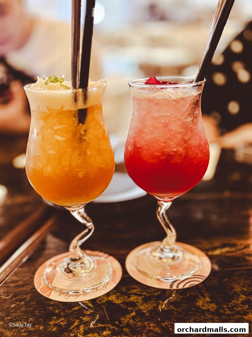 Two colorful, refreshing cocktails served in elegant glasses with straws.