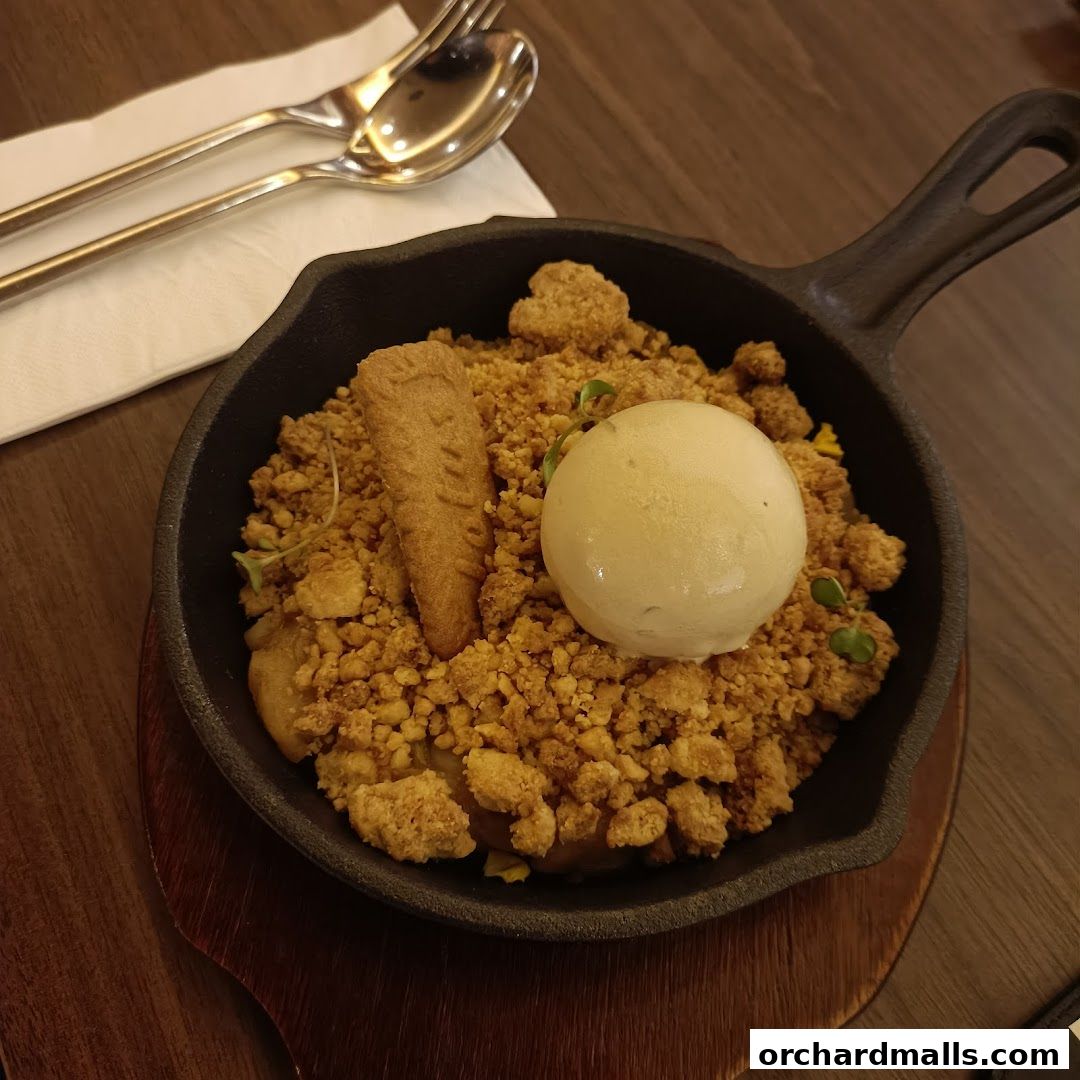A delicious dessert served in a cast iron skillet with ice cream and a biscuit.