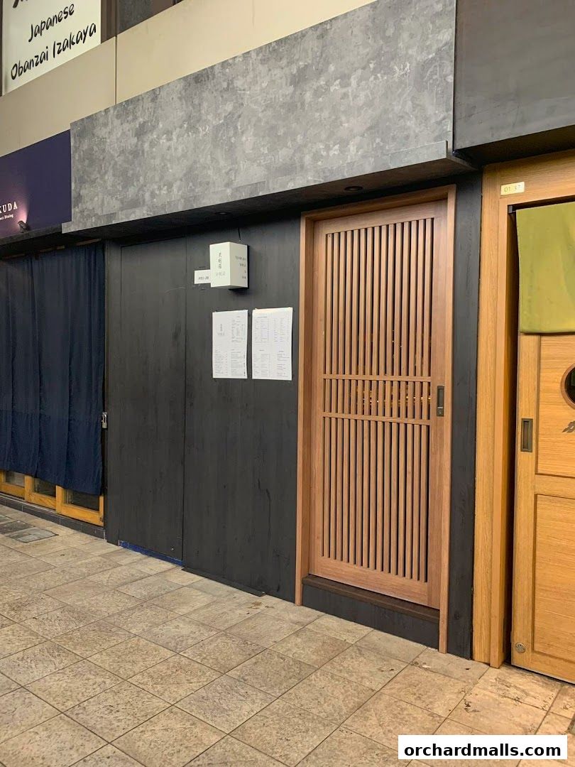 The entrance of Tempura SHIGE, a Japanese restaurant with a wooden door and signage.