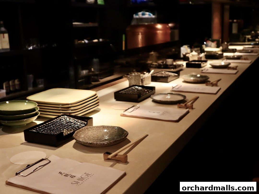 A counter at Tempura SHIGE with plates, bowls, and menus set for dining.