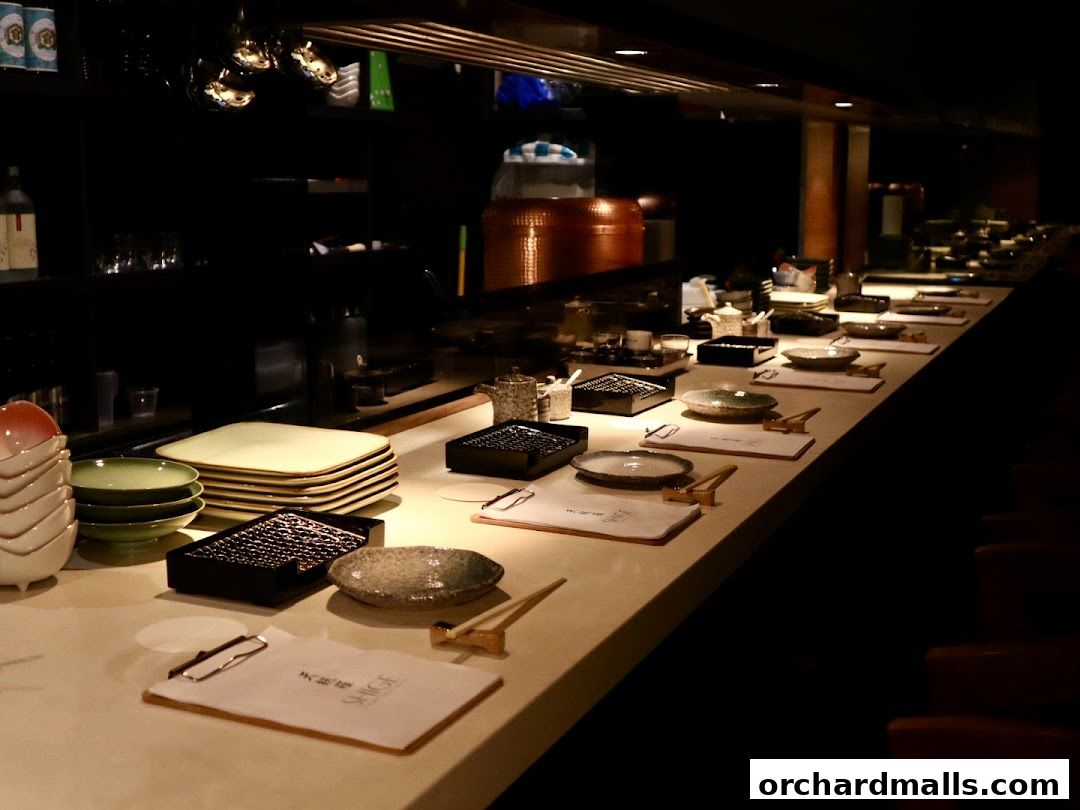 A long counter with place settings and stacks of plates at Tempura SHIGE.