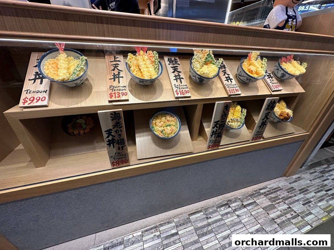 A display case showcasing various types of Japanese tendon bowls with prices.