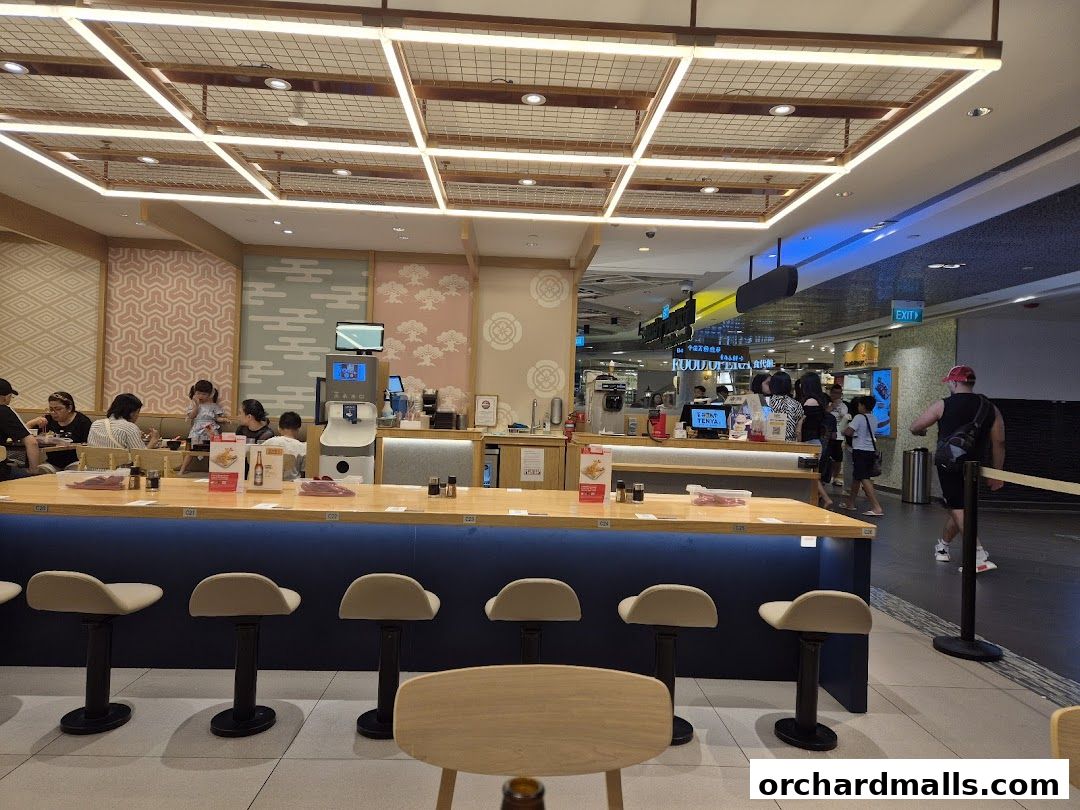 Interior of a Japanese restaurant with a counter seating area and customers dining.