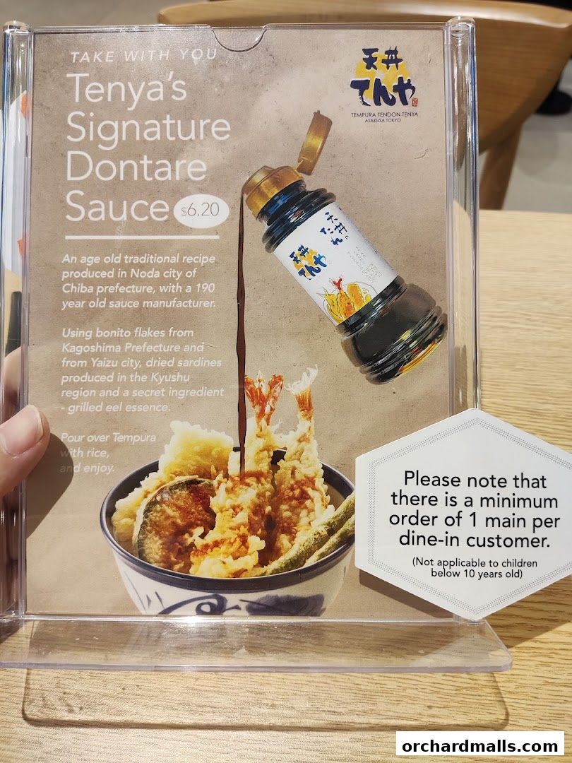 A bottle of Tenya's Signature Dontare Sauce displayed with a bowl of tempura.