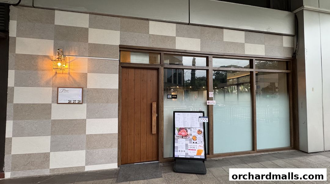 Exterior of Tetsu Japanese Cuisine with a wooden door and a digital menu board.