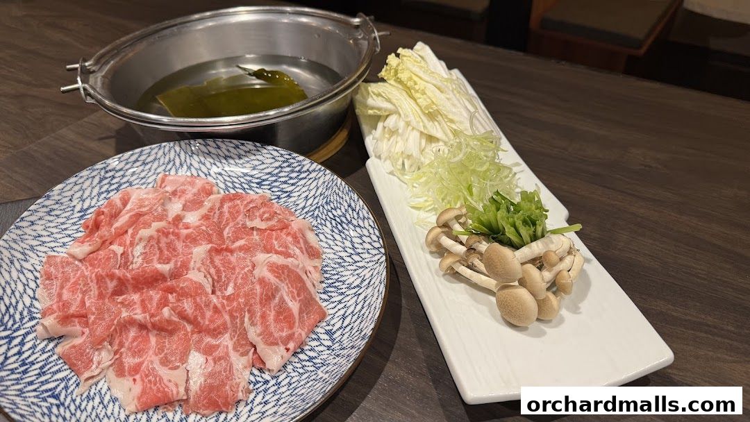 A plate of thinly sliced beef, vegetables, and mushrooms for hot pot.