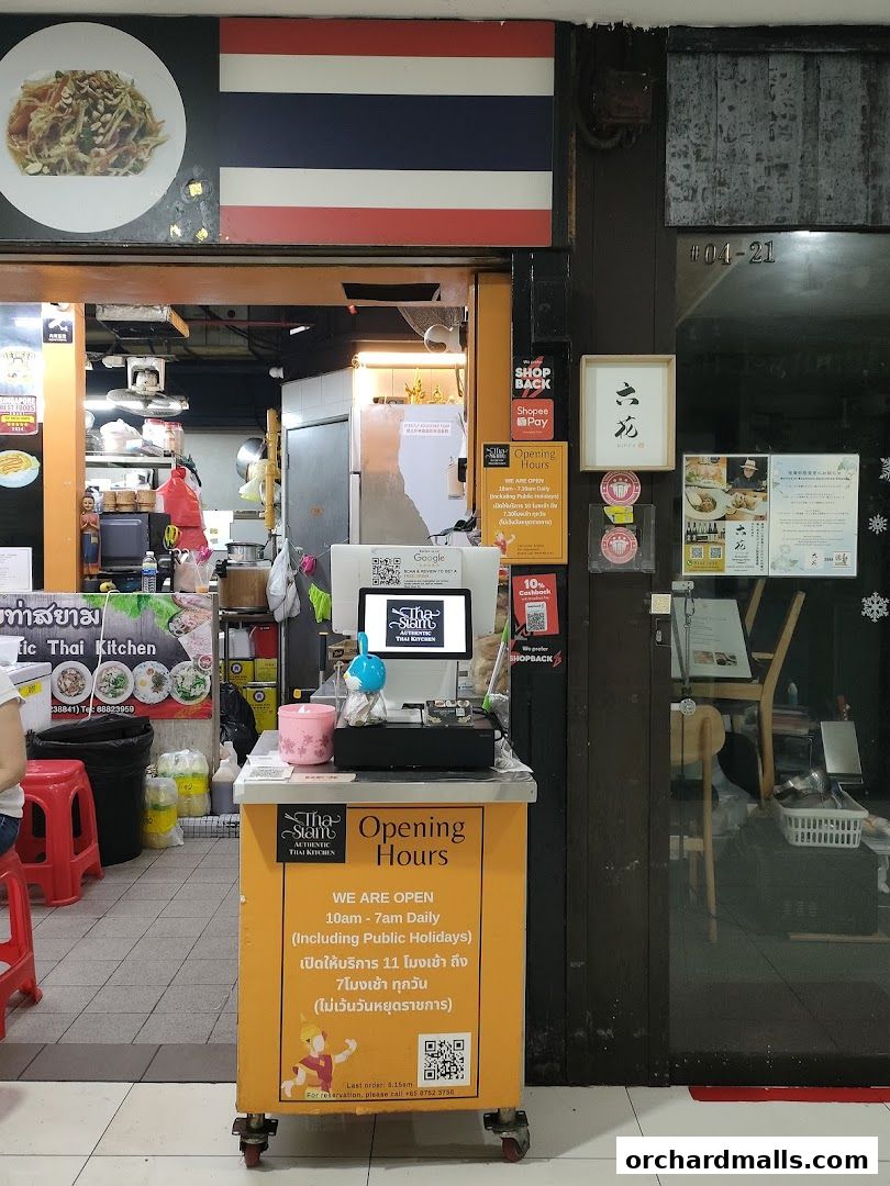 The entrance of Tha Siam Authentic Thai Kitchen with a display of opening hours and payment options.