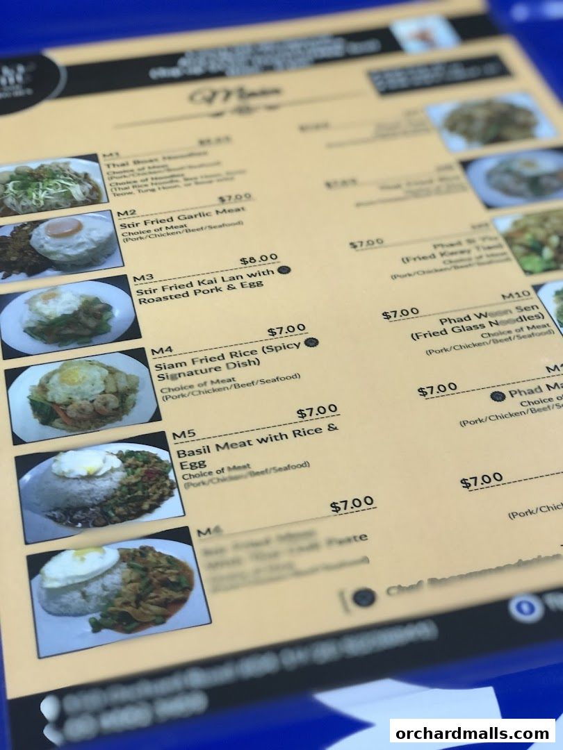 A close-up of a Thai restaurant menu featuring various dishes with prices and descriptions.
