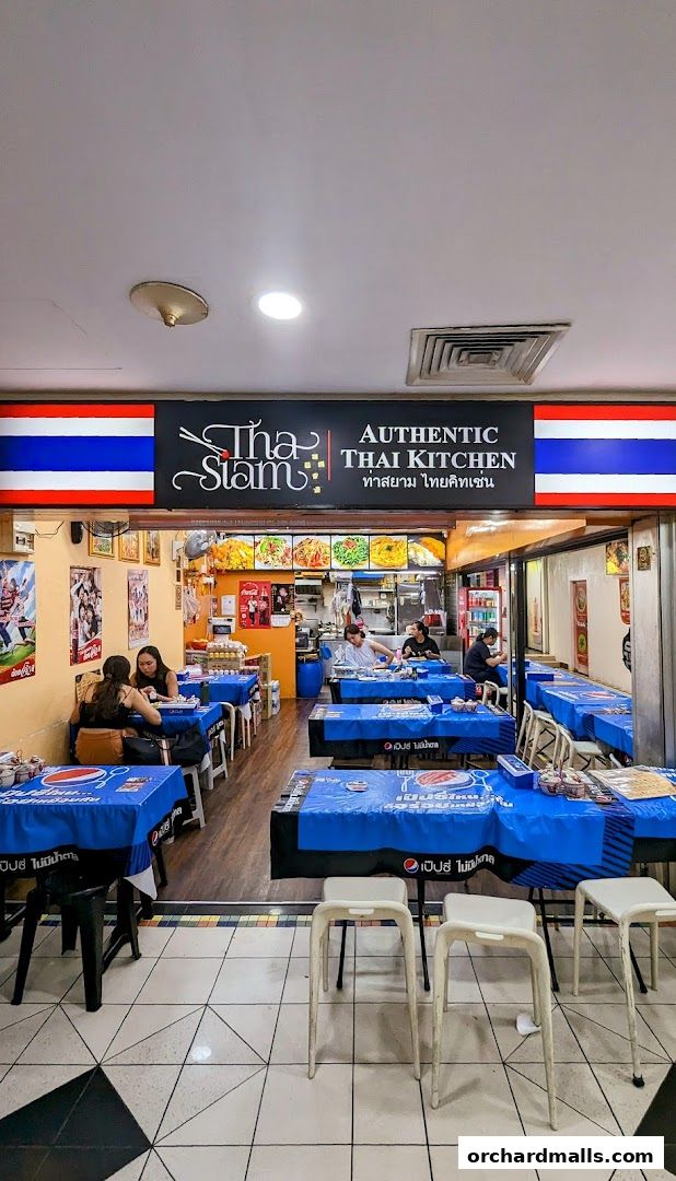 Interior view of Tha Siam Thai Kitchen restaurant with tables set for dining.