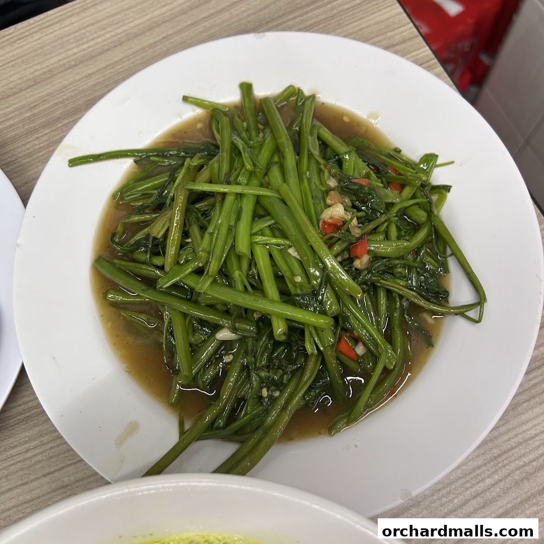 A plate of stir-fried water spinach with chili and garlic in a savory sauce.
