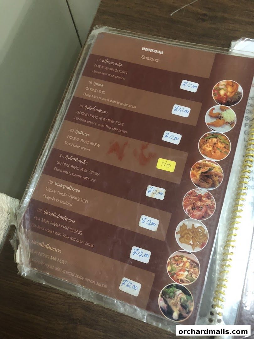 A close-up of a Thai restaurant menu featuring seafood dishes with prices.