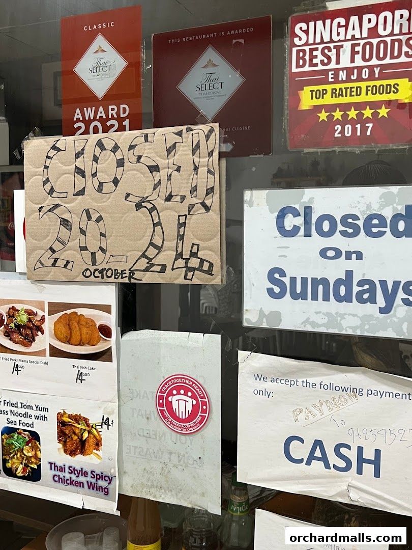 A shop window displays awards, a 'Closed on Sundays' sign, and a handwritten 'Closed October 2024' notice.