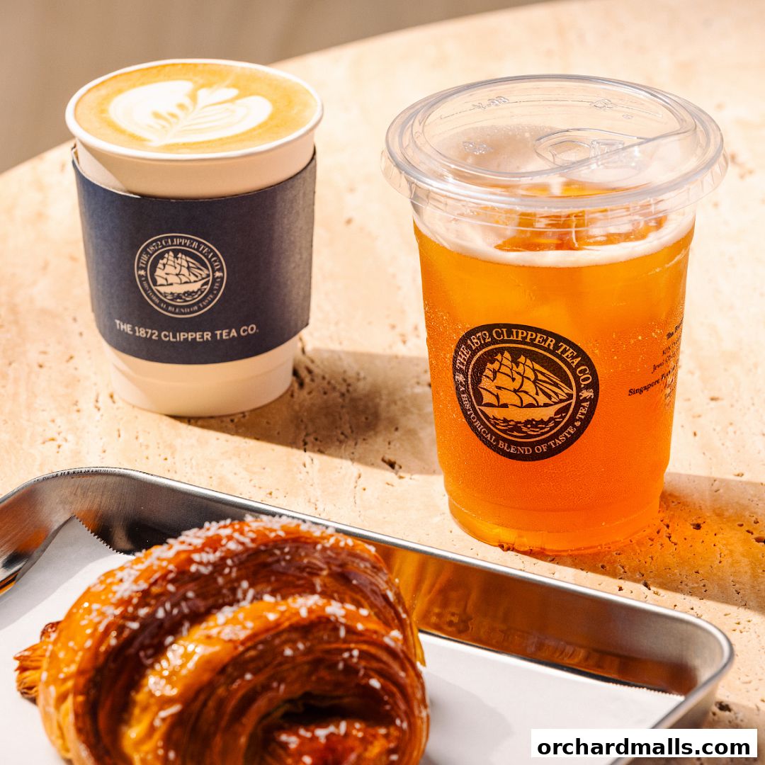 A coffee, iced tea, and croissant are displayed on a textured surface.