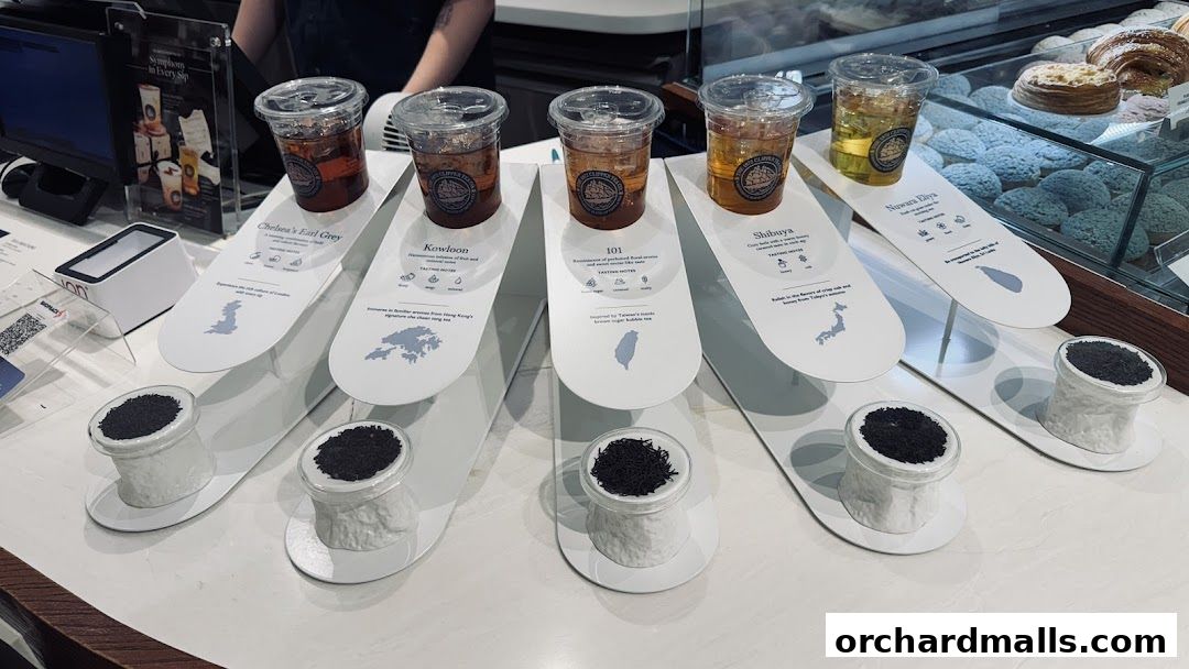 A display of iced teas with tea leaves and tasting notes for different locations.