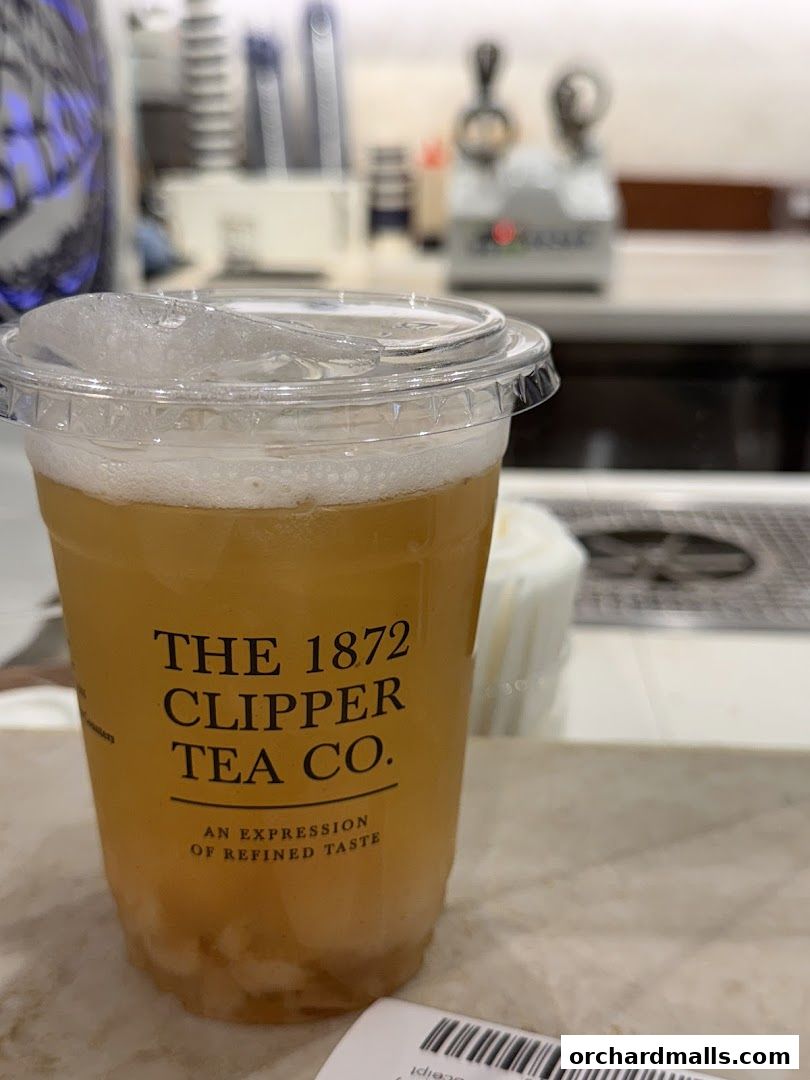 A close-up of a takeaway cup from The 1872 Clipper Tea Co. with a drink inside.