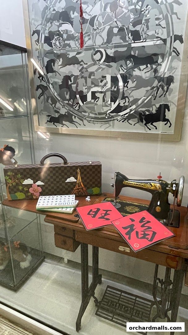 A vintage sewing machine with decorative items and Chinese calligraphy.