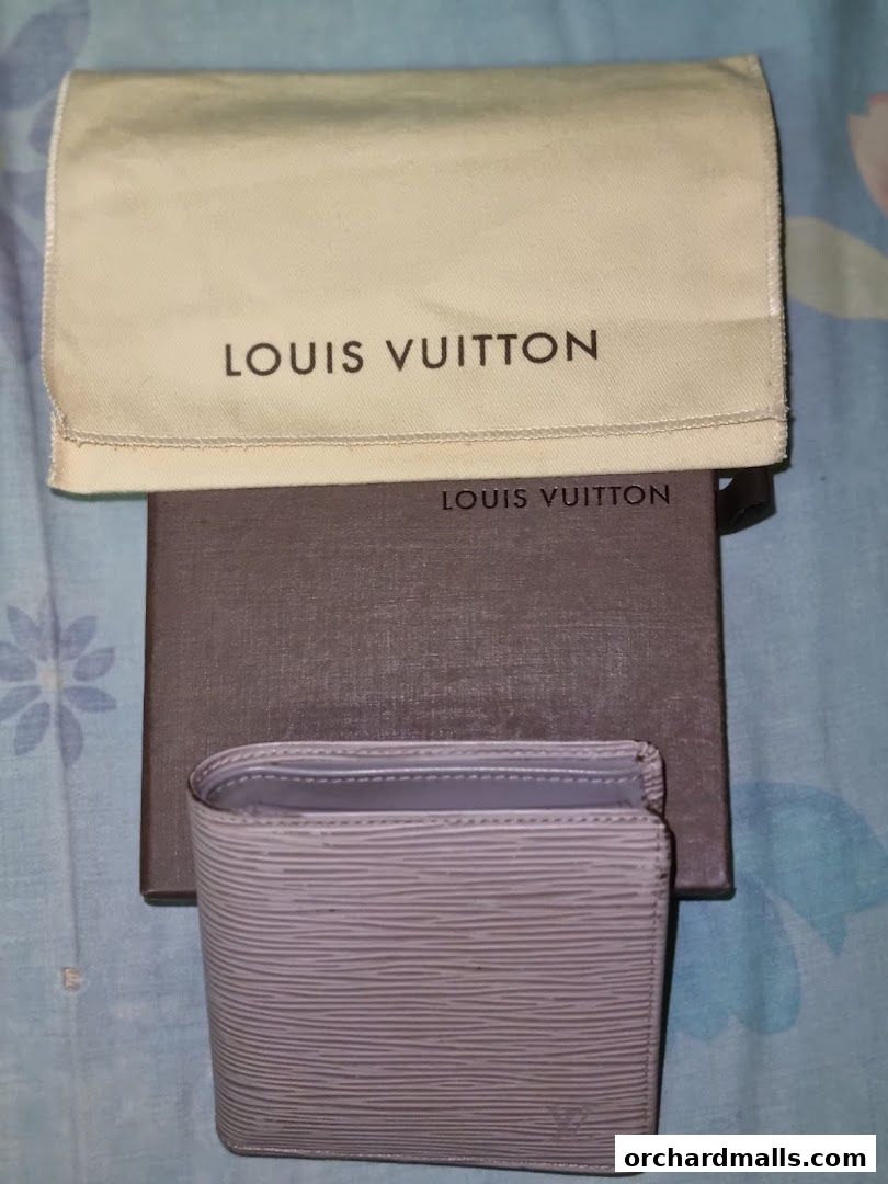 A Louis Vuitton wallet with its dust bag and box.
