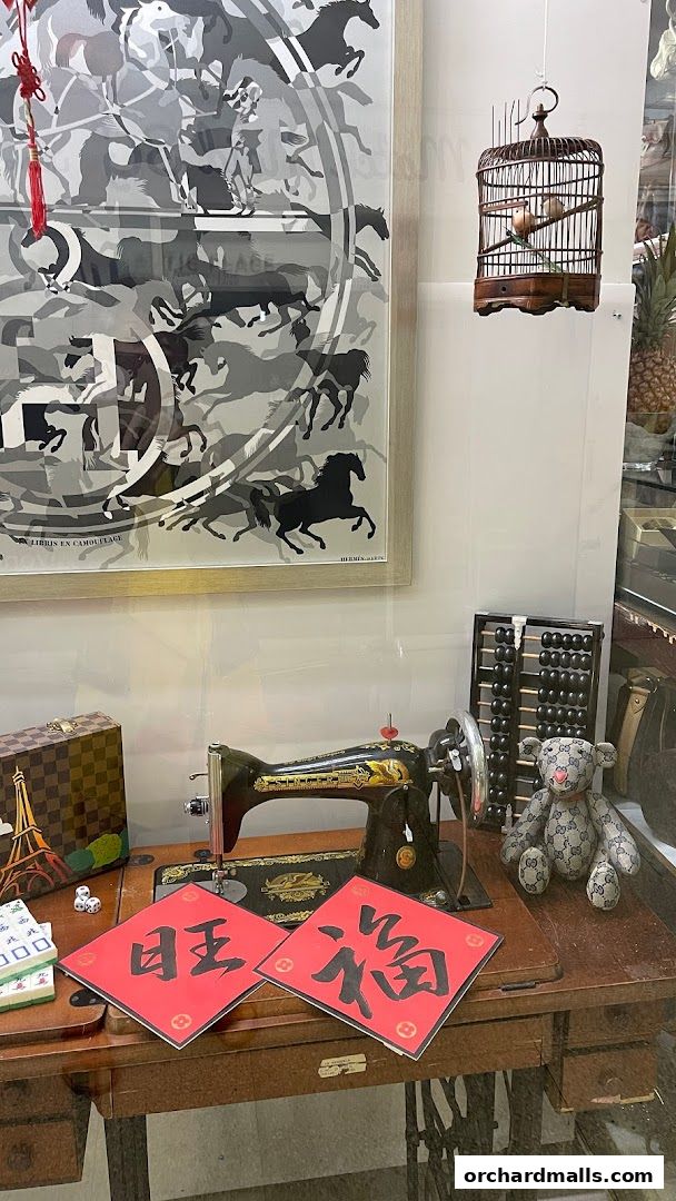 A vintage sewing machine display with decorative items and artwork.