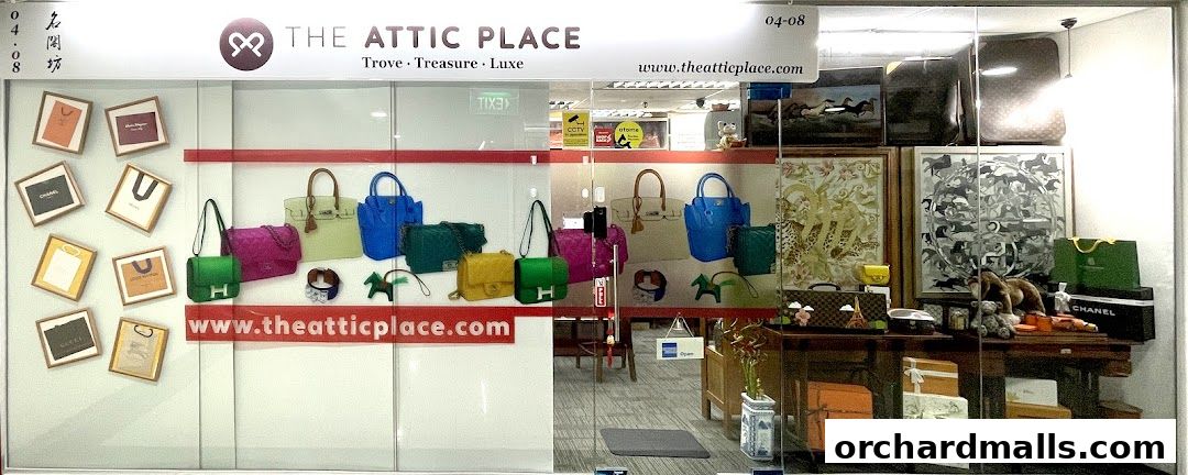 Shop window display featuring luxury handbags, framed shopping bags, and decorative items.