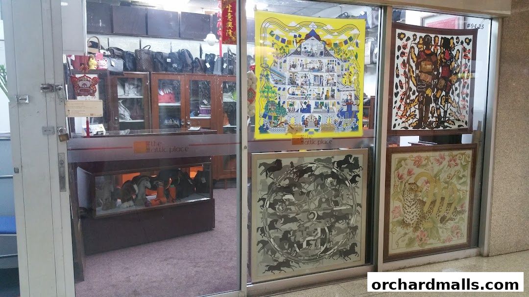 Shop entrance displaying various artworks and bags, with a display case of figurines.