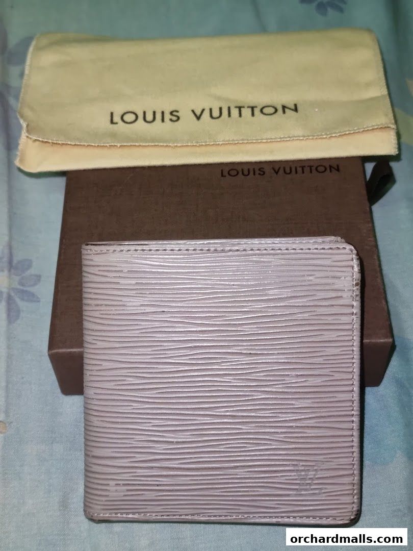 A light purple Louis Vuitton wallet with its dust bag and box.