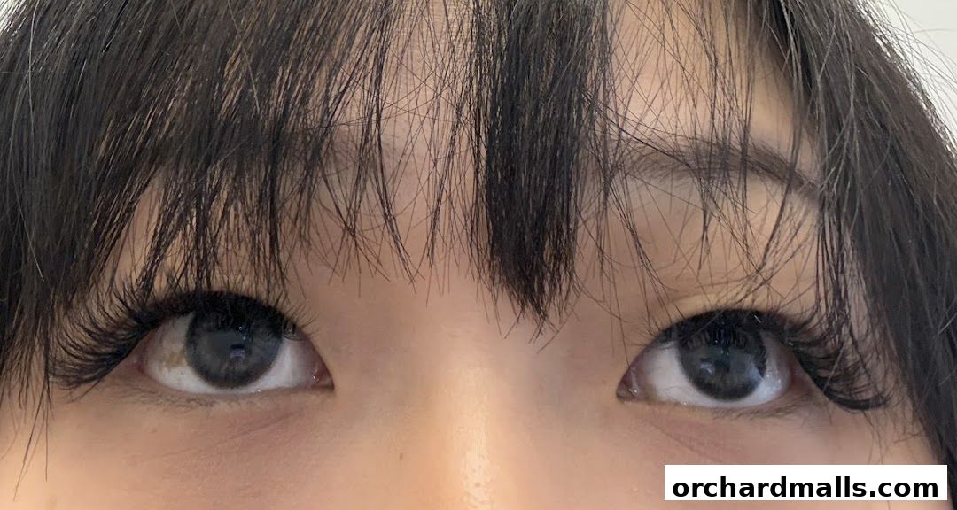 Close-up of a person's eyes with dramatic false eyelashes and bangs.