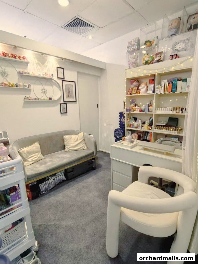 Interior of a beauty salon with a sofa, desk, chair, and shelves stocked with products.