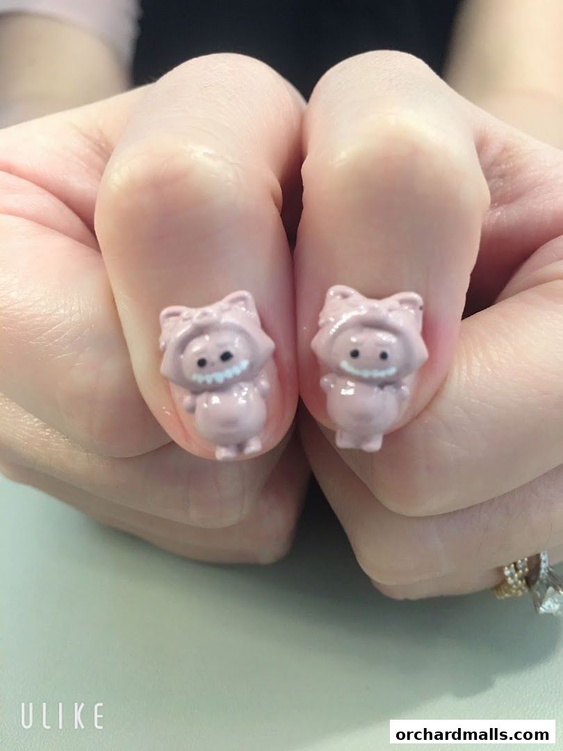 Close-up of hands with cute, pink, cartoon-themed nail art.